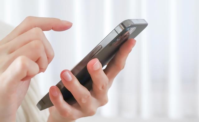 家族葬の高津区葬儀社に電話でお問合せしようとしている人の手元。